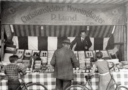 Her ses bager P. Lund fra Silkeborg i sin honningkagebod med ’Christiansfeldter Honningkager’ på et marked i Herning i 1938.