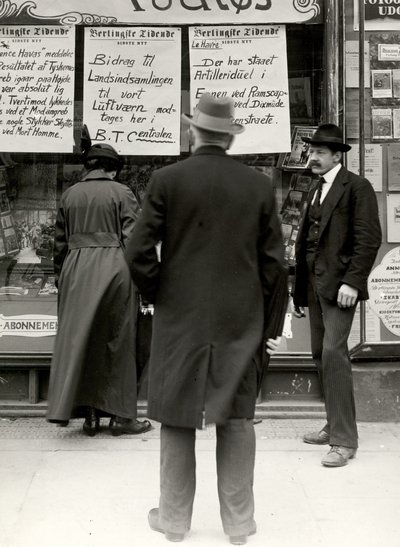 Mand læser nyheder, der er opslåede på butiksvindue under 1. verdenskrig