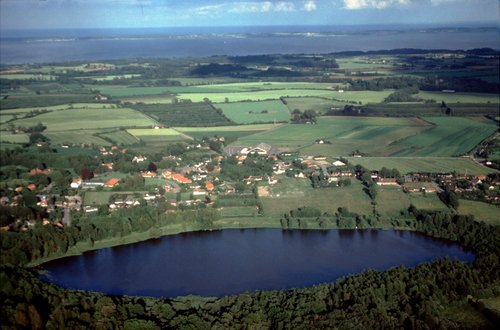 Luftfoto af Gudme Sø og landsbyen Gudme set fra vest