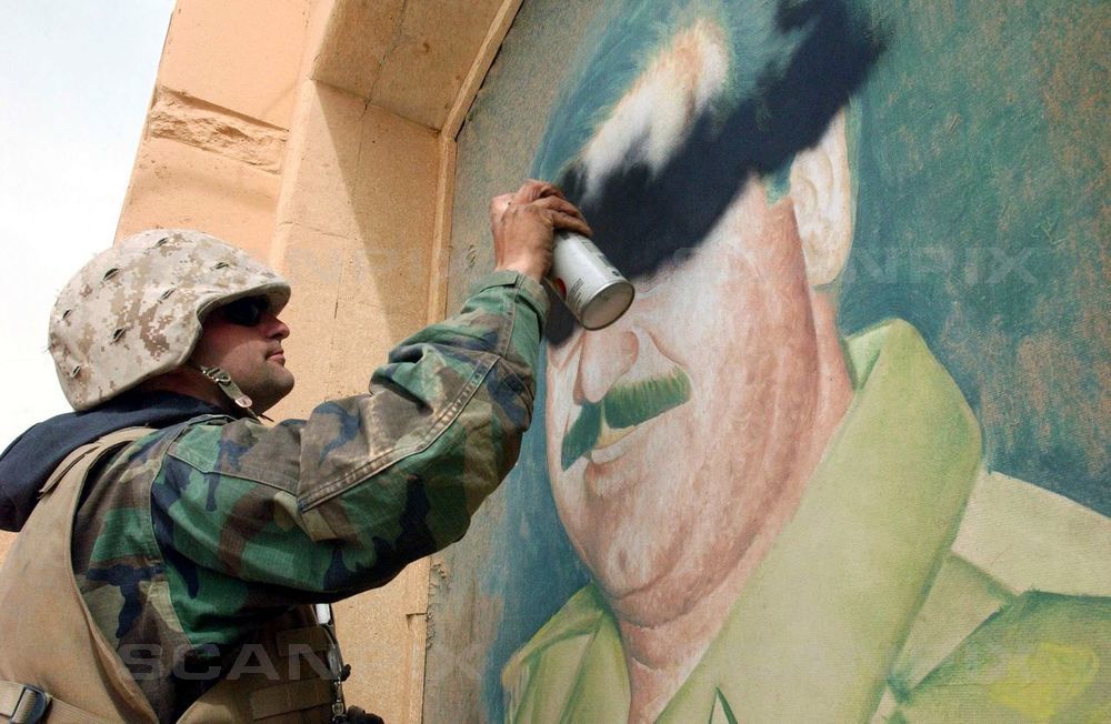 Aamerikansk marineofficer oversprayer portræt af Saddam Hussein